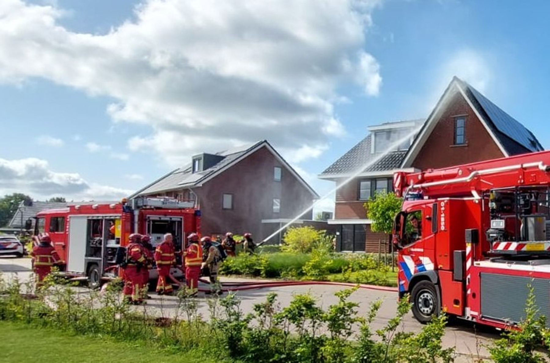 Brand onder zonnepanelen in Leek, brandweer zet hoogwerker in